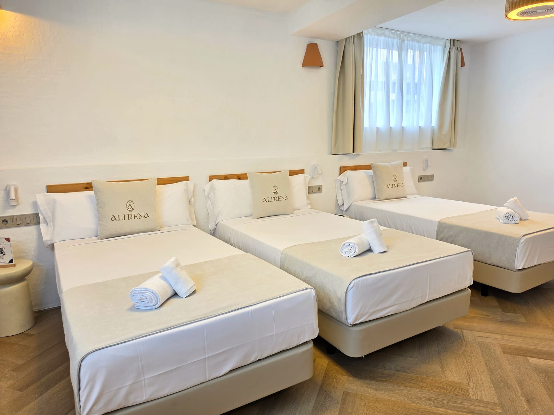 Habitación de la pensión: cama hecha, luz de día
